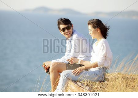 Couples Of Younger Asian Man And Woman Relaxing With Happiness On Vacation Beach