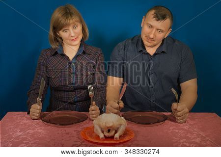 Studio Portrait Of Hungry People On A Blue Background. Want Will Regale On Poultry. Gluttony And Gre
