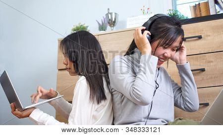 Asian Girl Listening Music And Learning E-learning With Headphones, Smiling Happy Searching Songs Mo