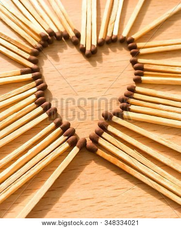 Wooden Safety Matches On A Wooden Background Arranged In The Shape Of A Heart. Matchsticks In The Sh