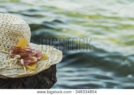 Sunny Hat With Flowers Lies On A Rock In Front Of The Sea, Toned