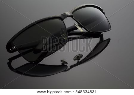 Folded Black Sun Glasses  On Black Background .