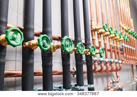 Plumbing service. copper pipeline of in boiler room. valves in row
