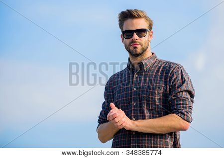 Man Eyewear Model Outdoors Blue Sky Background. Handsome Guy Wear Sunglasses. Hipster Man In Trendy 
