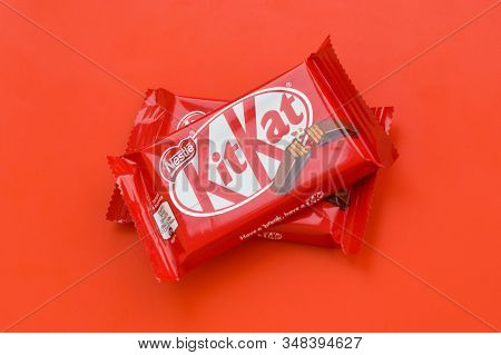 Kit Kat Chocolate Bar In Red Wrapping Lies On Red Background. Kit Kat Created By Rowntrees Of York I