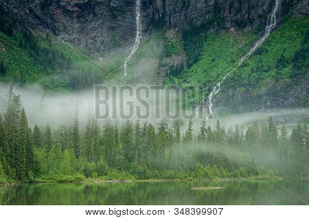 Waterfalls Rushing Down Mountain Side With Low Hanging Fog
