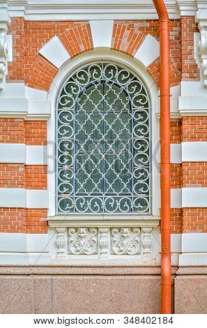 Close-up Of Ancient Vintage Arch Window With Cast Iron White Painted Deorative Lattice And White Ant