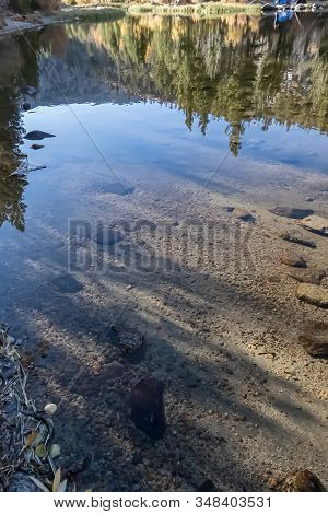 Lake Bed Through Transpatent Water With Reflections And Shadows