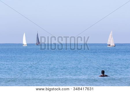 Landscape With Sailboats And A Man In The Water