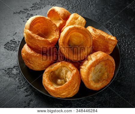 Traditional English Yorkshire Pudding Side Dish On Black Plate And Background