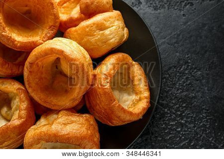 Traditional English Yorkshire Pudding Side Dish On Black Plate And Background