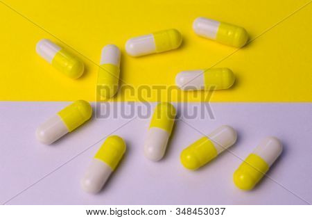 Yellow-white Capsules Of Celibacy On A Yellow-white Background. Medical Background.