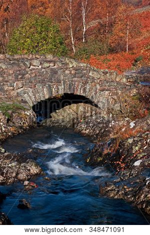 Ashness Bridge.  This Picturesque Humped Back Bridge Crosses Barrow Beck And Is A Landmark Close To 