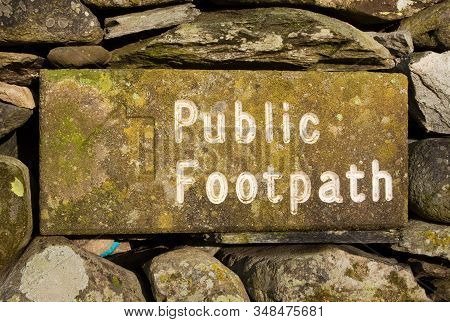 Stone Public Footpath Sign.  The Stone Public Footpath Sign Is Embedded In A Dry Stone Wall And Is S