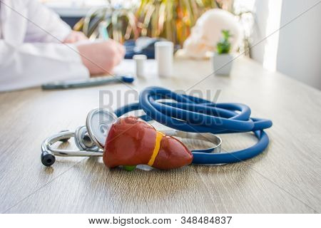 Concept Photo Of Diagnosis And Treatment Of Liver. In Foreground Is Model Of Liver Gallbladder Near 