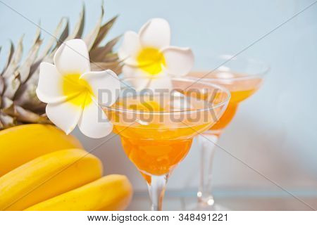 Glasses Of Tropical Exotic Multifruit Juice Cocktail Drink With Plumeria Frangipani Flower. Troical 