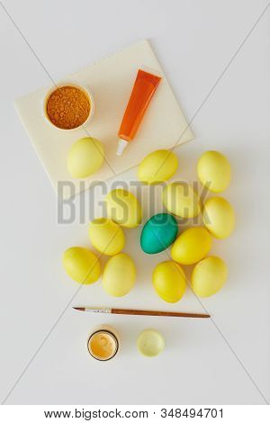 Above View Of Natural Colored Easter Eggs With Green Accent And Paint Brush Arraigned In Minimal Com