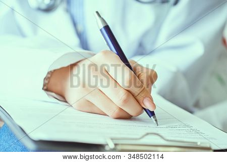 Female Doctor Hand Hold Silver Pen Filling Patient History List At Clipboard Pad. Panacea And Life S