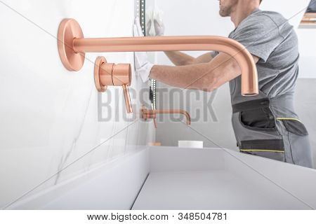 New Bathroom Finish Cleaning. Copper Color Elegant And Stylish Faucet And White Ceramic Sink. Bathro