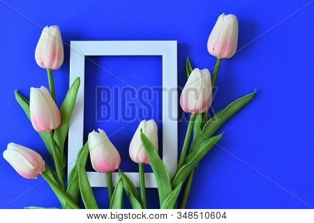 Photo Frame And Flowers On A Classik Blue Background. Pink Tulip. Copy Space In The Middle For Your 