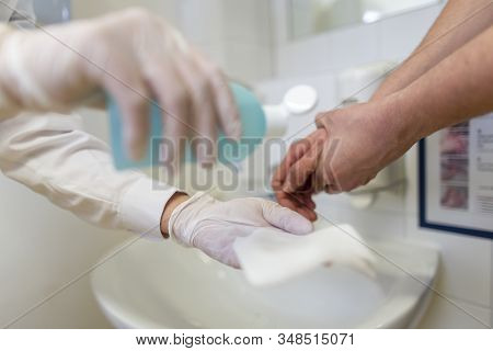Nurse Disinfects A Patients Hand At A Sink