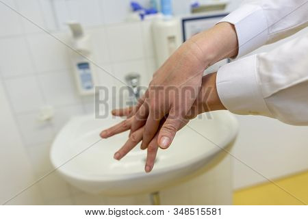 A Nurse Disinfects Her Hands In A Hospital Room