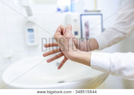 A Nurse Disinfects Her Hands In A Hospital Room