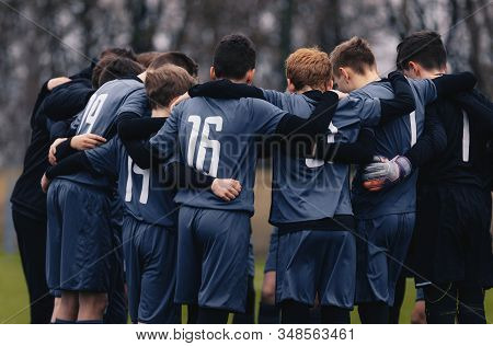Soccer Team With Junior Coach Gathering Together In A Circle, To Strategize And Motivate. Football Y