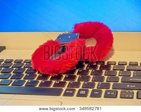 Metal Handcuffs And Computer. Love And Cyber Sex Concept