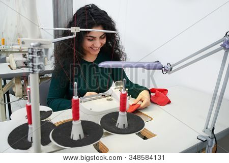 Dressmaker Using Professional Overlock Sewing Machine In Workshop Studio. Equipment For Edging, Hemm