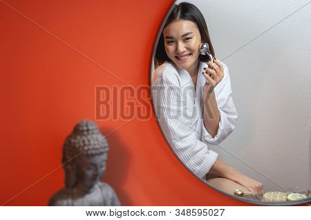 Asian Amazing Woman Using Modern Massagers For Facebuilding