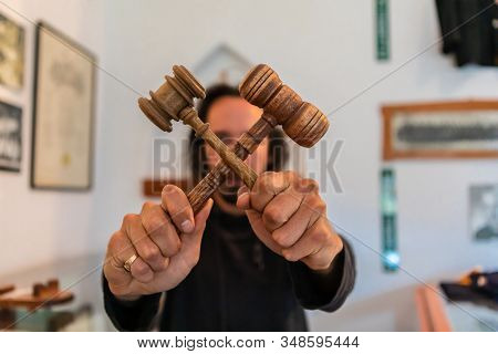 Young Man Holding Two Wooden Hammers Crossed Showing As A Symbol Of No Justice And Corruption Concep