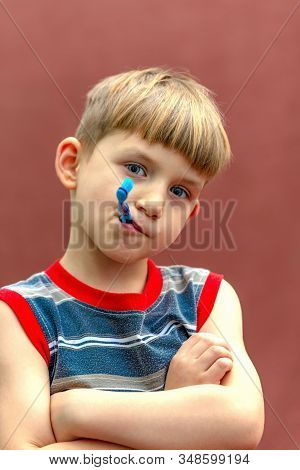 The Child Holds A Toothbrush In His Hand Near His Mouth