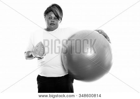Studio Shot Of Fat Black African Woman Holding Exercise Ball And Slice Of Watermelon Ready For Gym