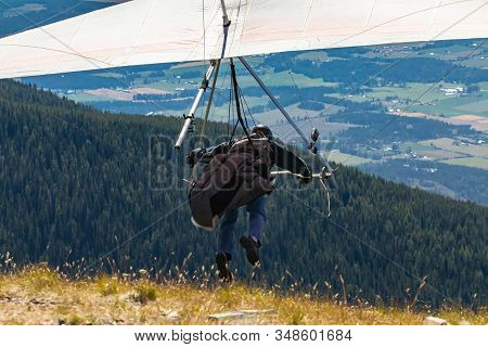 Professional Hang Glider Man Running And Taking Off. View From The Back. Hang Gliding Air Sport In A
