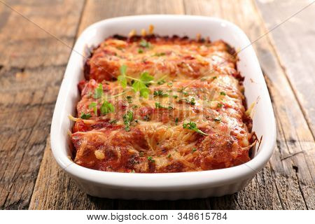 pasta gratin with beef, tomato sauce and cheese- traditional canneloni