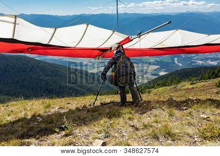 Young Paraglider Preparing To Take Off From The Ground. Extreme Air Sports Lovers Enjoying Weekend A