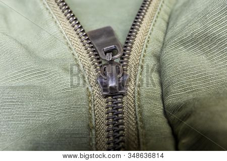 Fragment Of Partially Fastened Metal Zipper Fastener With Metal Puller On The Outerwear Olive Color 