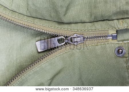 Fragment Of Partially Fastened Metal Zipper Fastener With Metal Puller And Unbuttoned Snap Button Fa