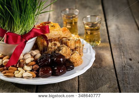 Nowruz Holiday Concept - Grass, Baklava Sweets, Nuts And Seeds, Copy Space