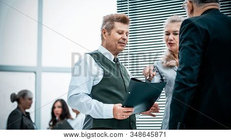 Close Up. Serious Employees Discuss Something Standing In The Office.