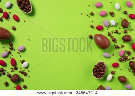 Egg Hunt Is Coming. Easter Traditions, Chocolate Eggs, Candies On Green Background, Top View, Copysp