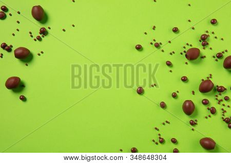 Egg Hunt Is Coming. Easter Traditions, Chocolate Eggs, Candies On Green Background, Top View, Copysp