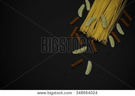 Different Spaghetti On Black Background. Top View. Pasta.