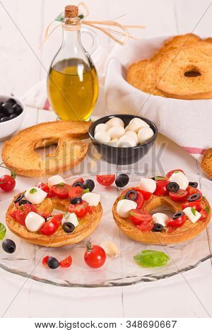 Friselle With Tomatoes And Mozzarella Cheese On Wooden Table.