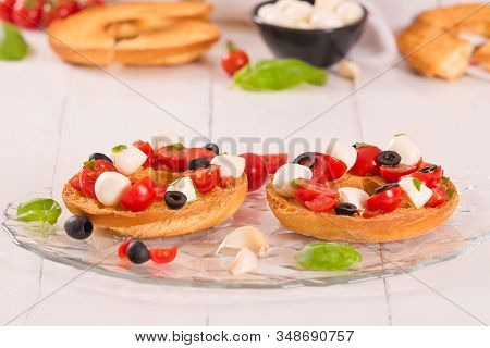 Friselle With Tomatoes And Mozzarella Cheese On Wooden Table.