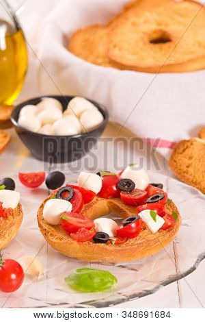 Friselle With Tomatoes And Mozzarella Cheese On Wooden Table.