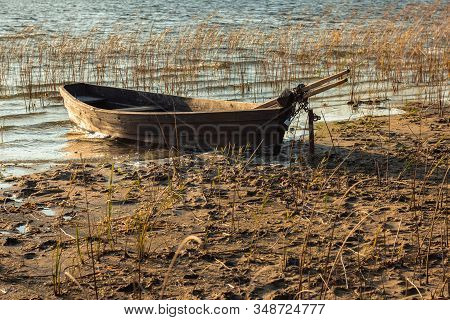 Old Wooden Boat Moored On The Mudy Shore Lake