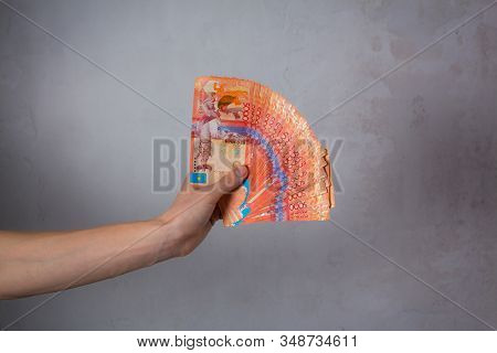 Hand Hold A Lot Of Money. Tenge Kzt. National Currency Of Kazakhstan, Kz. Exchange Rate. Economy, De