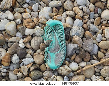 Turquoise Old Bathing Shoe On The Pebble Beach